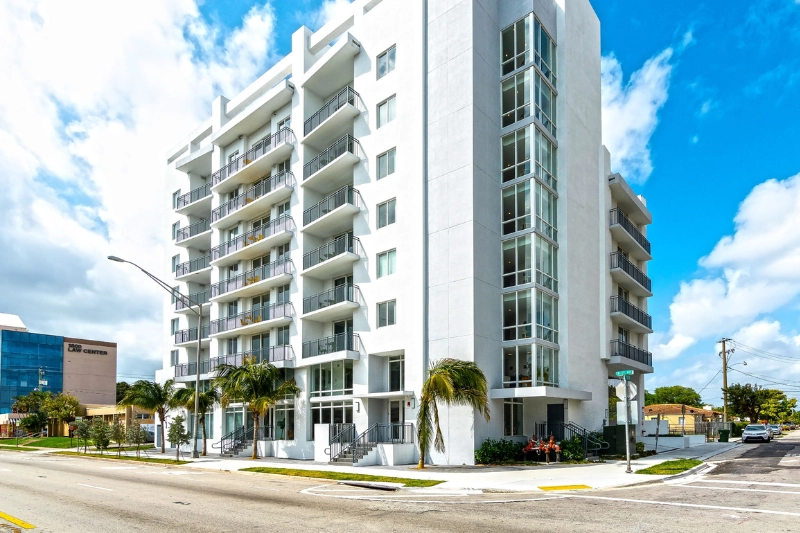 modern white high rise apartment building exterior at grove 27 by roami in miami