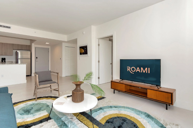 living area with wooden tv console and round coffee table at grove 27 by roami