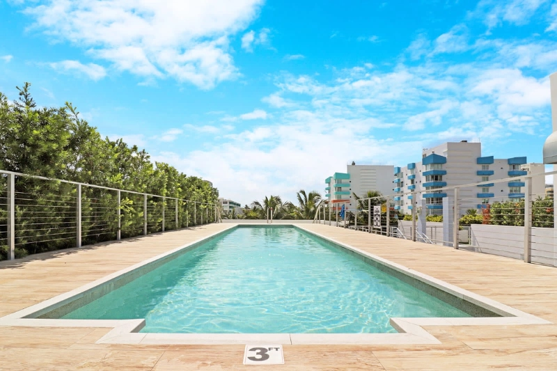 rooftop lap pool with wooden deck at 250 collins by roami in miami beach