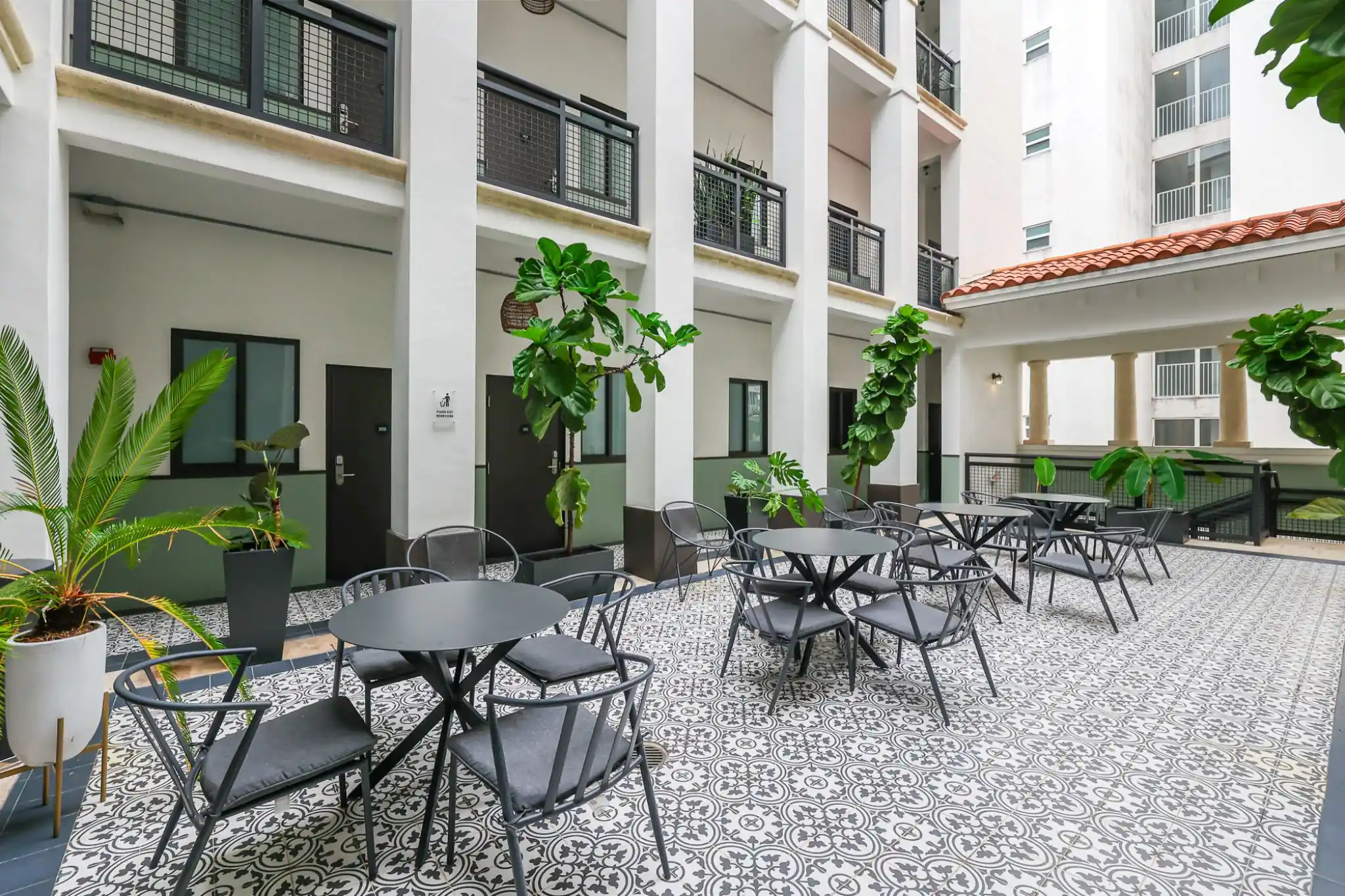 tiled courtyard patio with bistro tables and plants at the palace by roami