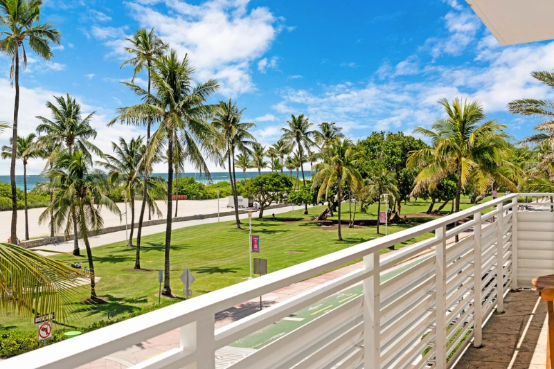 balcony view of palm trees and park on ocean drive at 1200 ocean by roami