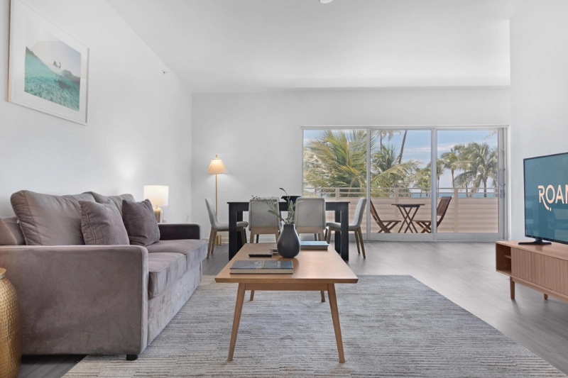living room with grey sofa and balcony doors at 1200 ocean by roami