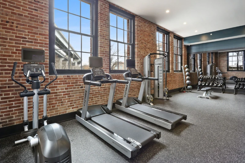 fitness center with treadmills and brick walls at the lola by roami