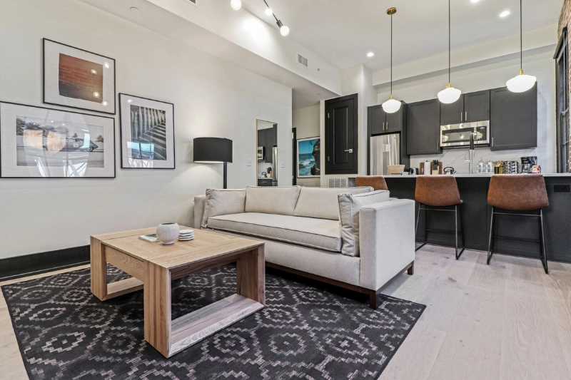 living room with white sofa patterned rug and kitchen bar at the lola by roami