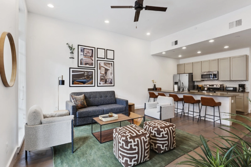 living room with blue sofa gallery wall and kitchen island at bourbon place by roami
