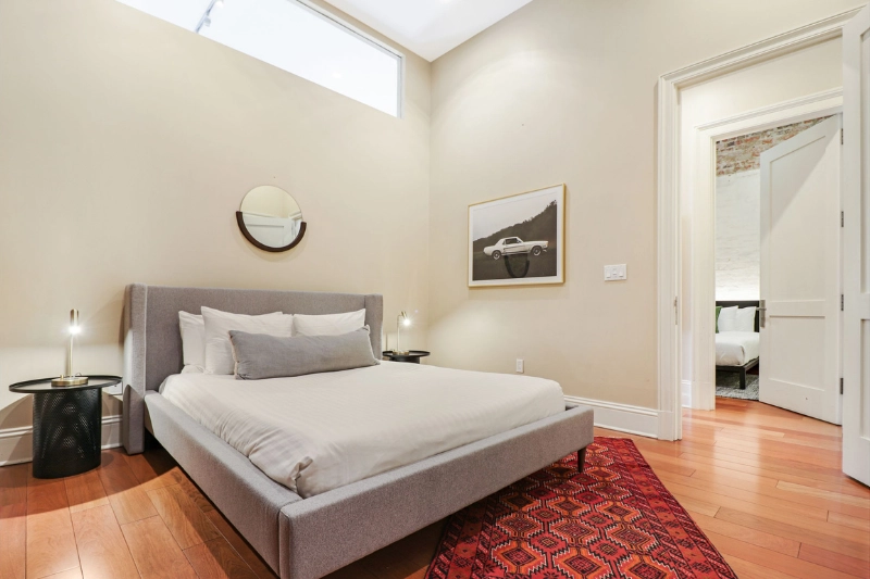 bedroom with grey upholstered bed and red rug at factors row by roami