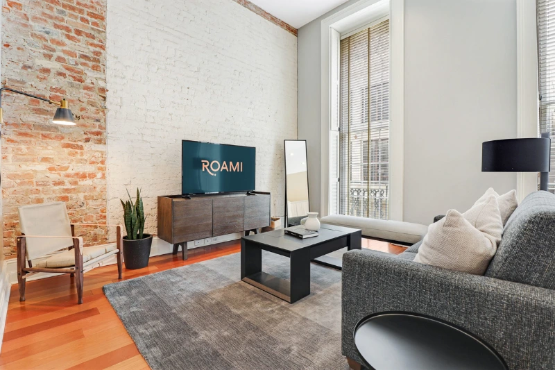 living room with tall windows exposed brick and grey sofa at factors row by roami