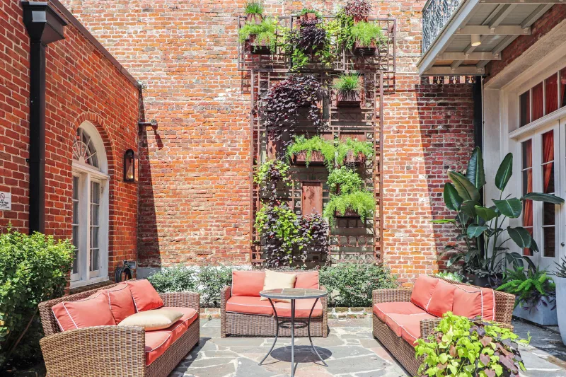 brick courtyard with living plant wall and wicker seating at factors row by roami
