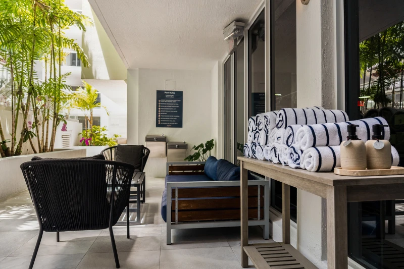 pool deck cabana with rolled striped towels and outdoor seating