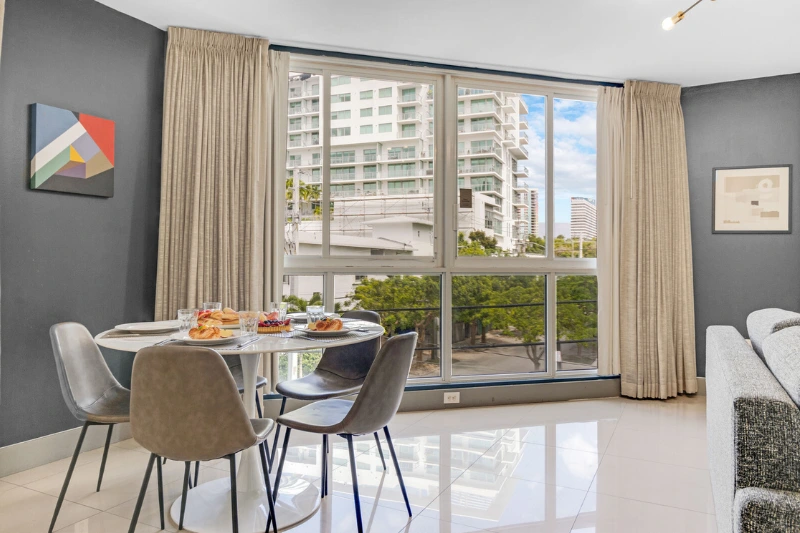 round dining table by floor to ceiling windows with city view