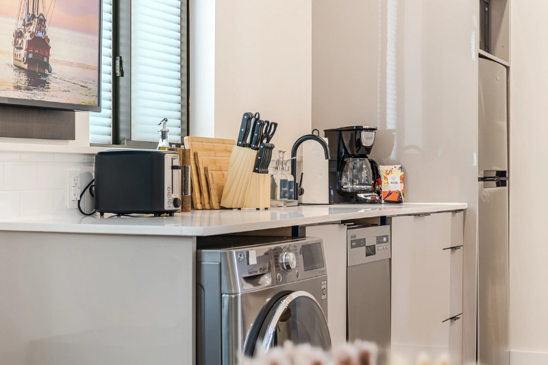 kitchen counter with coffee maker microwave and washer dryer