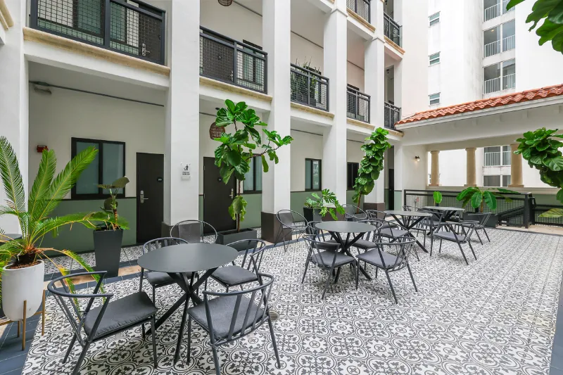 courtyard patio with tiled floor bistro tables and potted plants