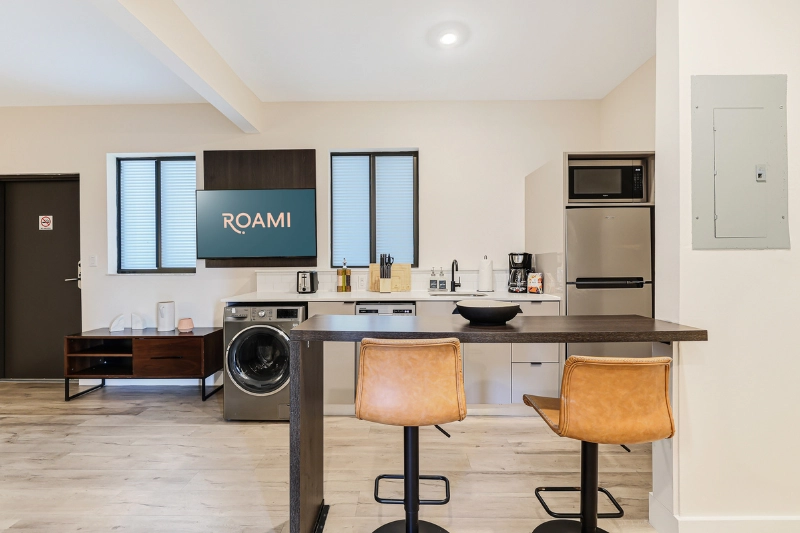studio apartment kitchen with island bar stools and washer dryer