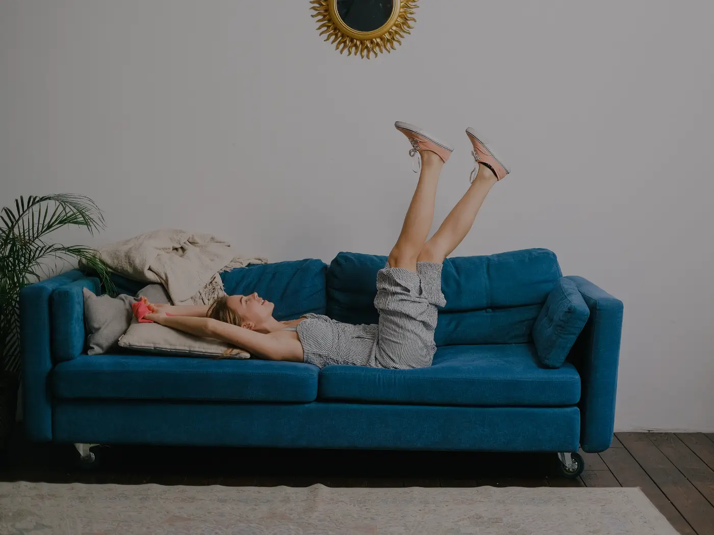 woman relaxing on a blue sofa with her legs up during a midterm stay in new orleans