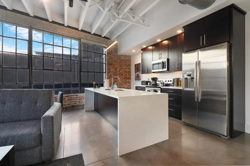 modern loft kitchen with island and steel appliances at motorworks by roami