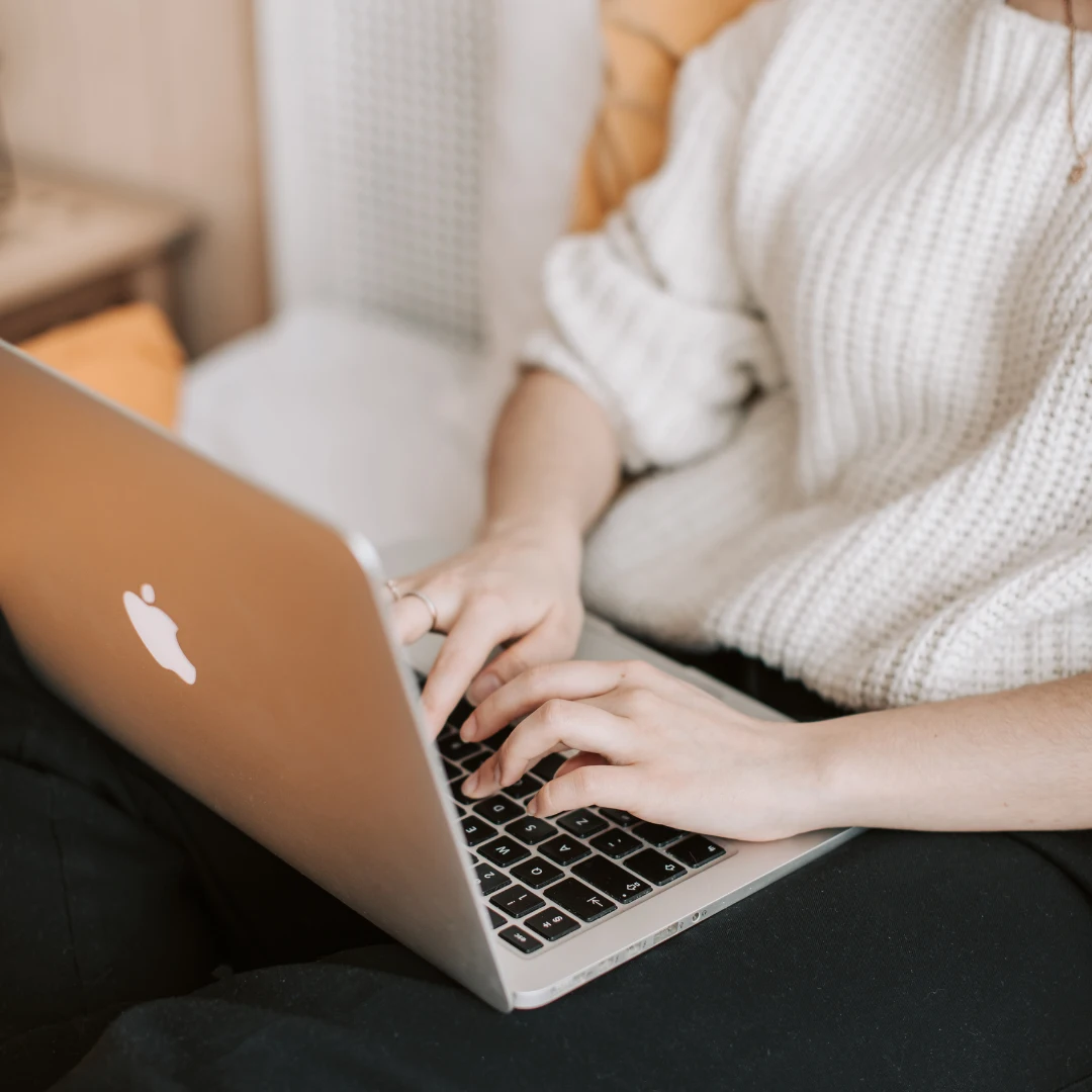 person typing on a laptop to choose travel dates