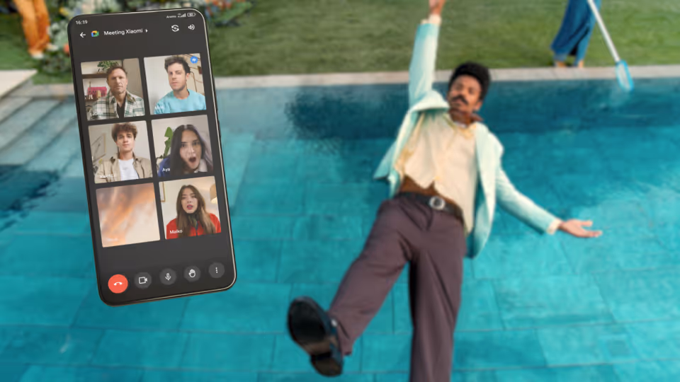 a man standing in a pool holding up a cell phone