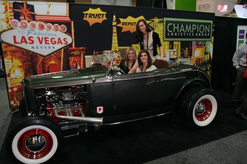 Champion employees sitting in a classis car at the annual Exhibitor Tradeshow in Las Vegas, Nevada.