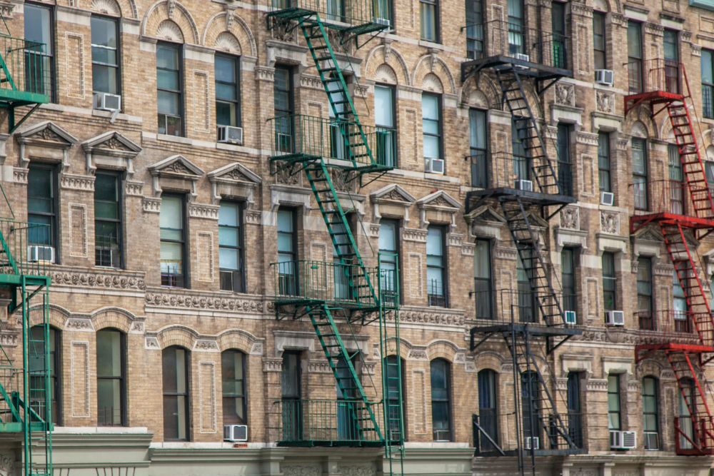 Rent-regulated residential building with fire escapes in Harlem, New York City