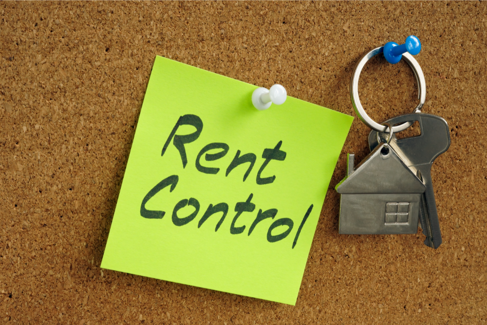 Rent control note with apartment key pinned to bulletin board
