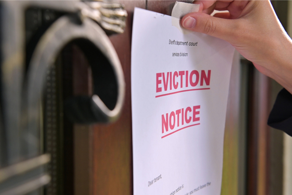 Hanging an eviction notice on an apartment door‍