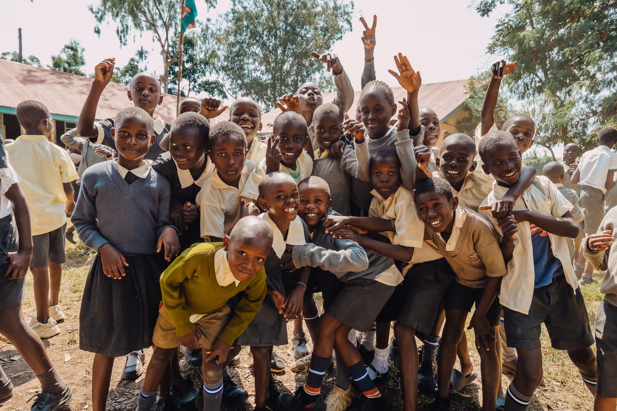 Joyful group of African schoolchildren in uniforms celebrating together