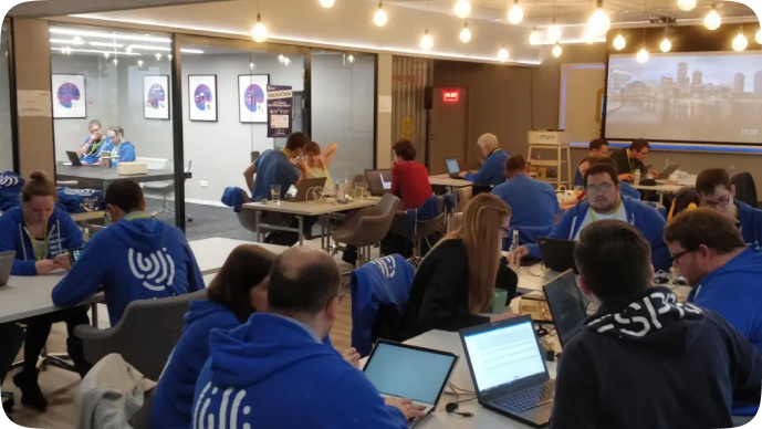 Lissi-Teammitglieder in blauen Hoodies arbeiten bei einem gemeinsamen Workshop an Laptops