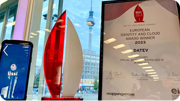 Trophäe und Siegerurkunde des European Identity and Cloud Award 2023 für DATEV in der Kategorie „Decentralized ID in Practice“, daneben ein Smartphone mit der Lissi-App