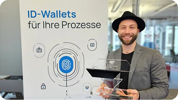Adrian Doerk mit der Trophäe des Handelsblatt Diamond Star Award vor einem Banner mit der Aufschrift „ID-Wallets für Ihre Prozesse“