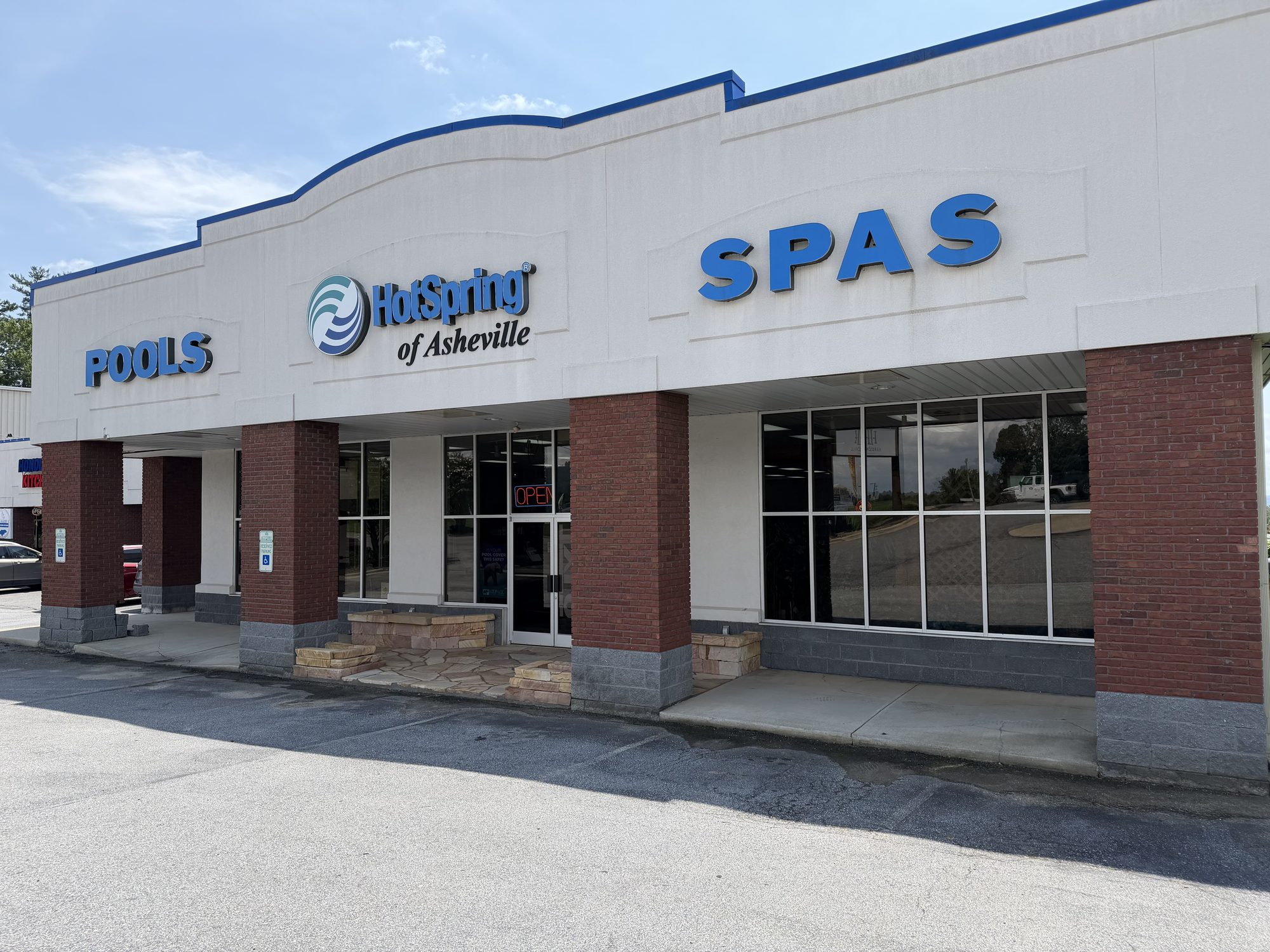 Hot Spring of Asheville storefront with brick columns and blue POOLS & SPAS signage on Airport Rd, Asheville, NC