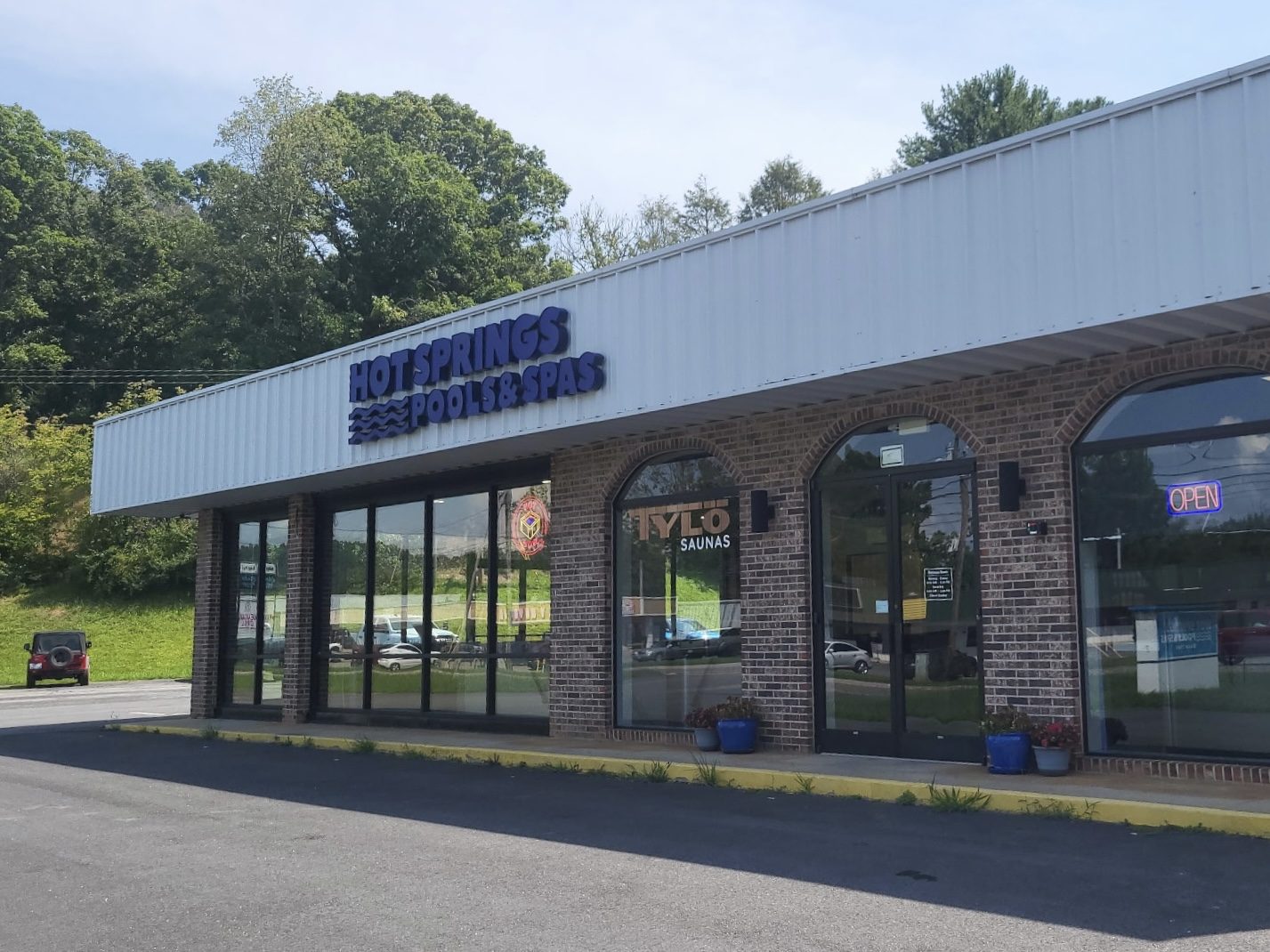 Brick Hot Springs Pools & Spas storefront with metal canopy signage on Highlands Rd in Franklin, NC