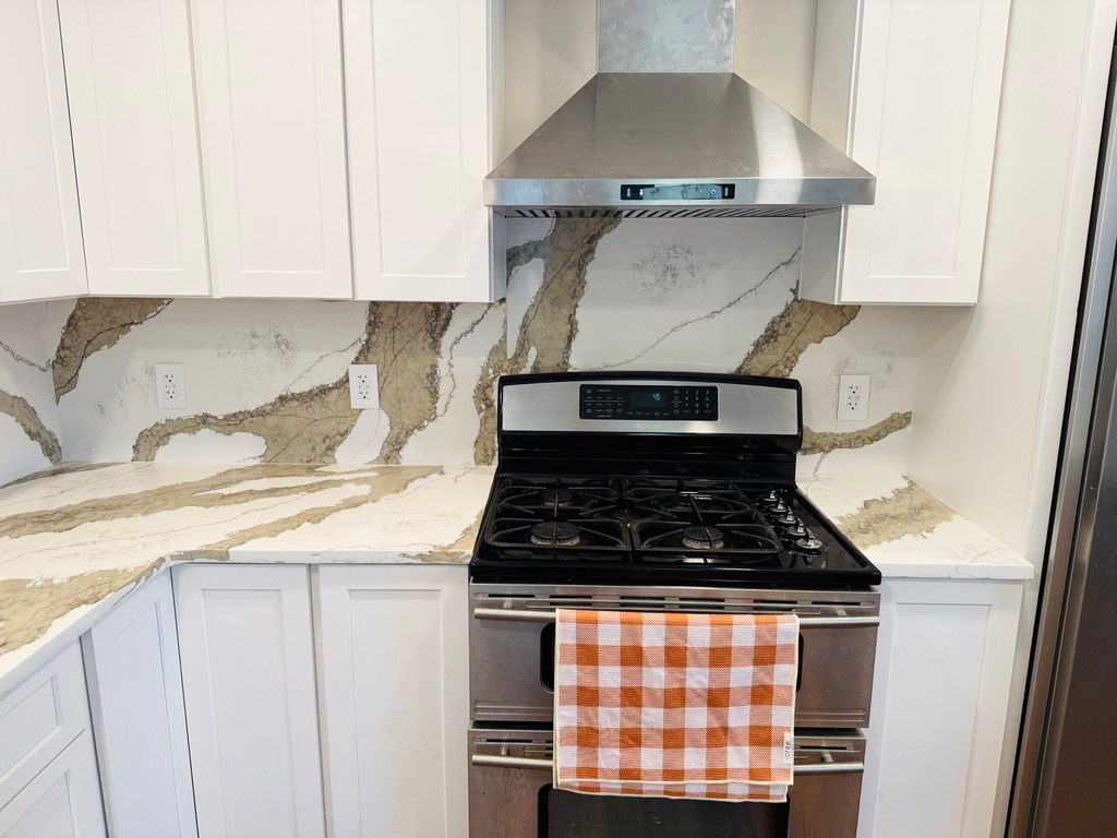 Bold Statement Kitchen: Full-height quartz backsplash with dramatic veining in Johnston, IA - Quartz Impressions