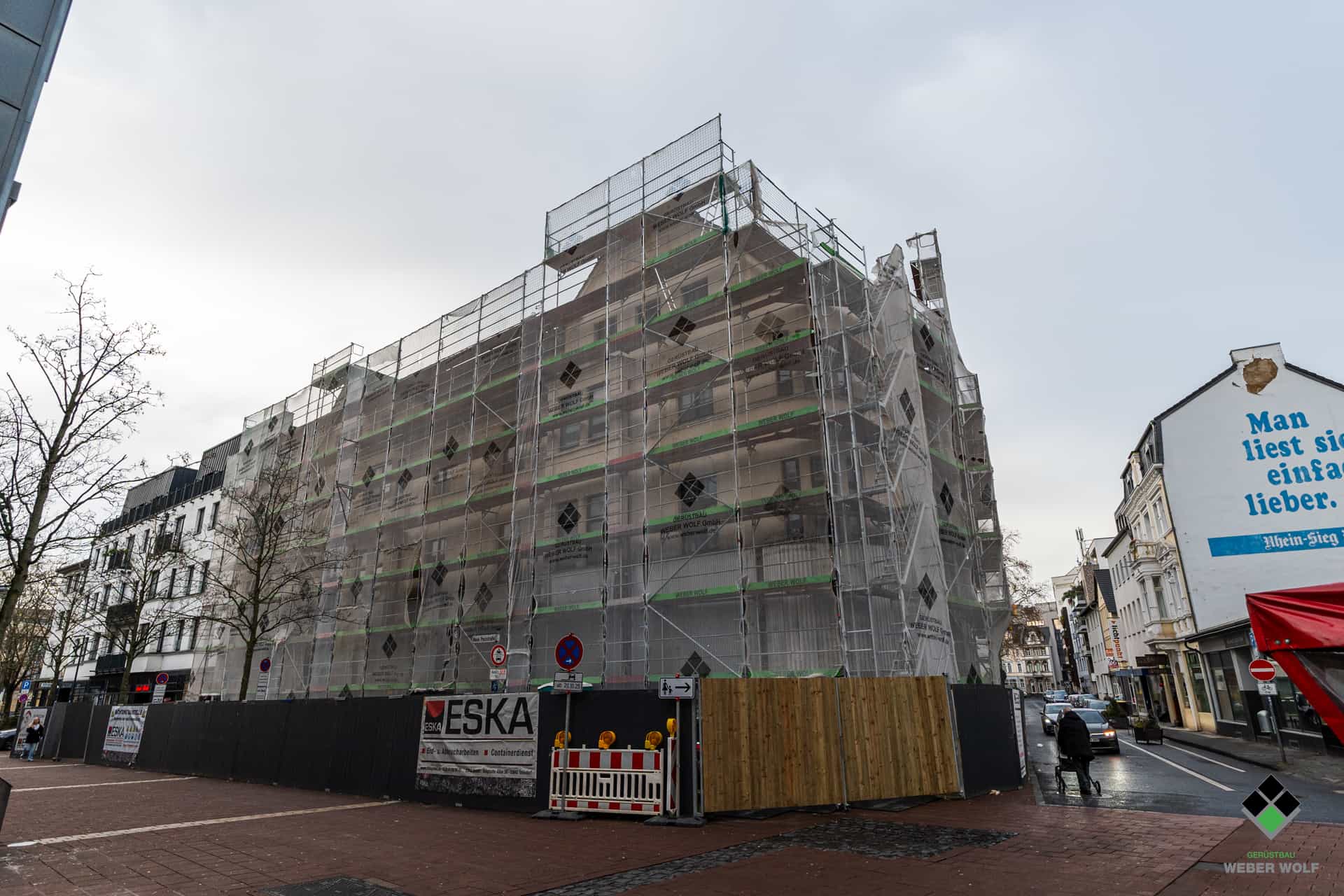 Ein Gebäude in der Siegburg Innenstadt, ausgestattet mit Fassadengerüst und Dachfanggerüst vom Weber Wolf Gerüstbau.