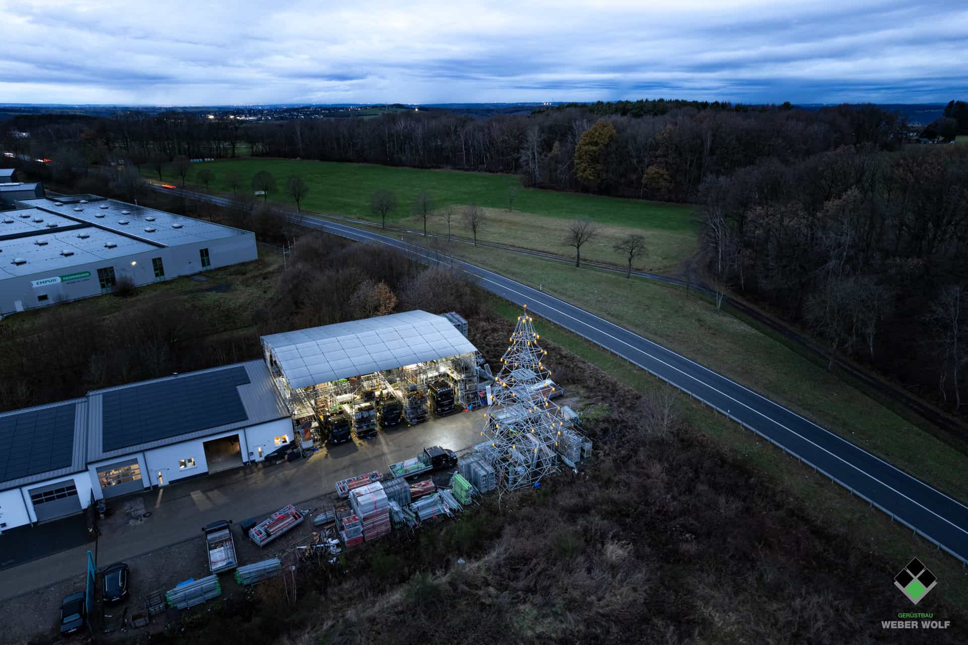 Luftaufnahme vom Zentrallager des Weber Wolf Gerüstbau zur Weihnachtszeit mit einem Weihnachtsbaum aus Modulgerüst an der B8 in 53567 Buchholz.