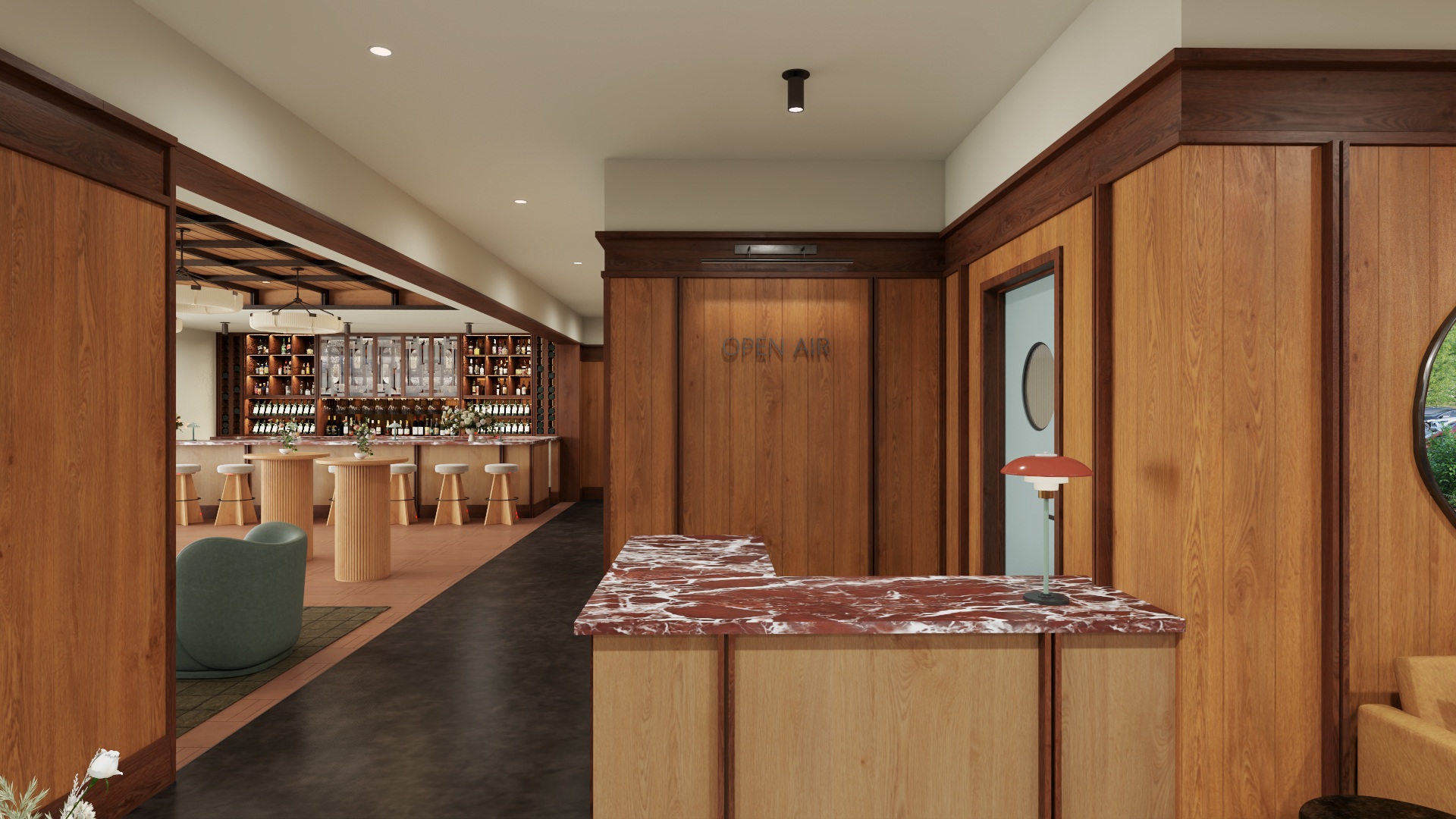 Modern lobby area with wooden panel walls, red marble-topped reception desk, a red lamp, green chair, and a bar with stools in the background.