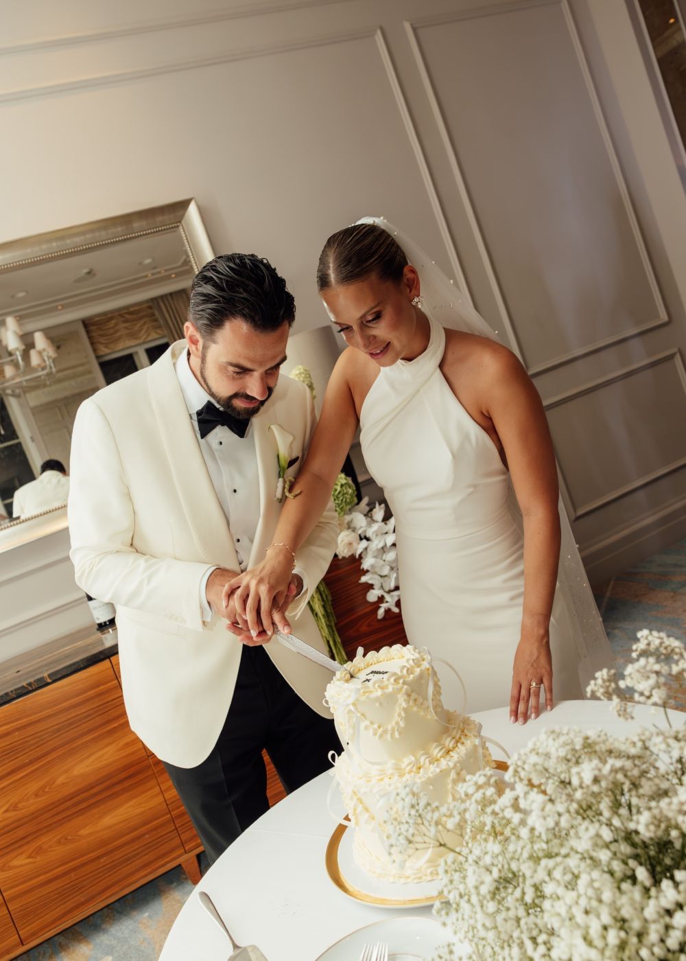 wedding couple making their first cut into the wedding cake at Waldorf Astoria Hotel Amsterdam