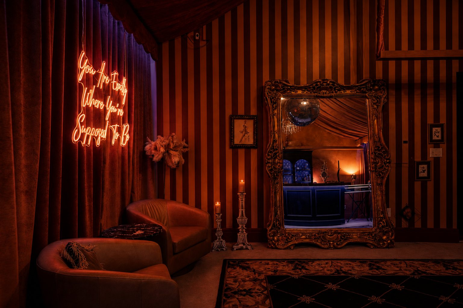 Neon sign reading You Are Exactly Where You're Supposed To Be beside a gilded mirror