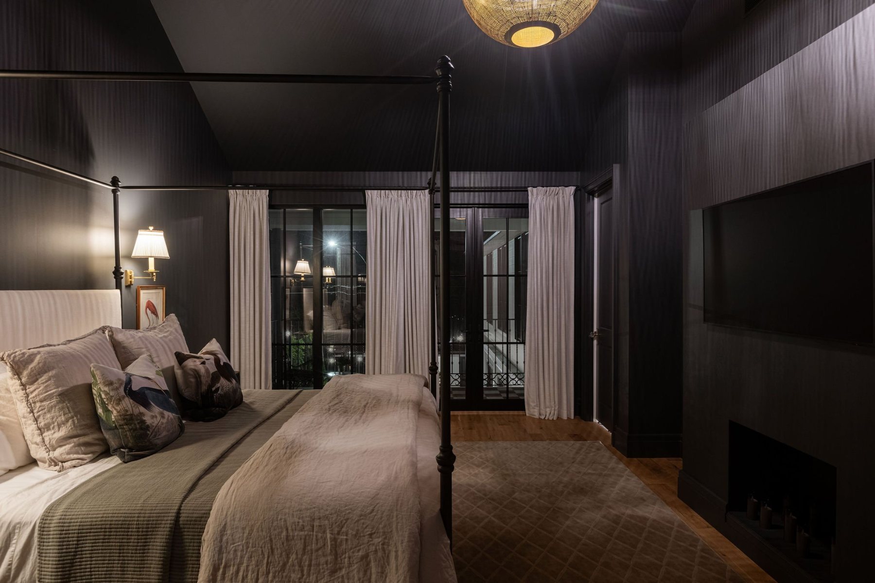 Primary bedroom with canopy bed and fireplace