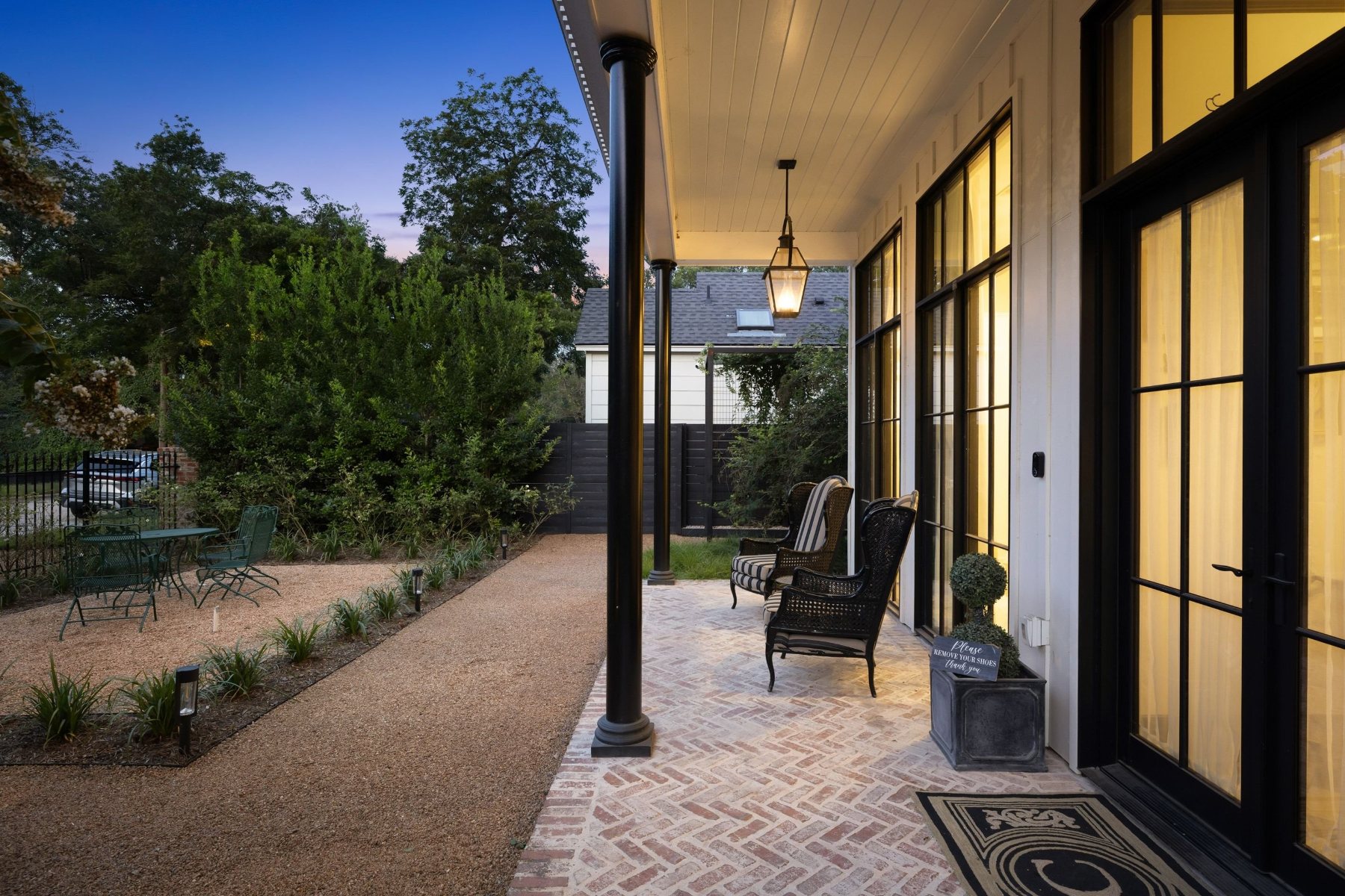 Brick front porch at dusk with lanterns and glowing windows