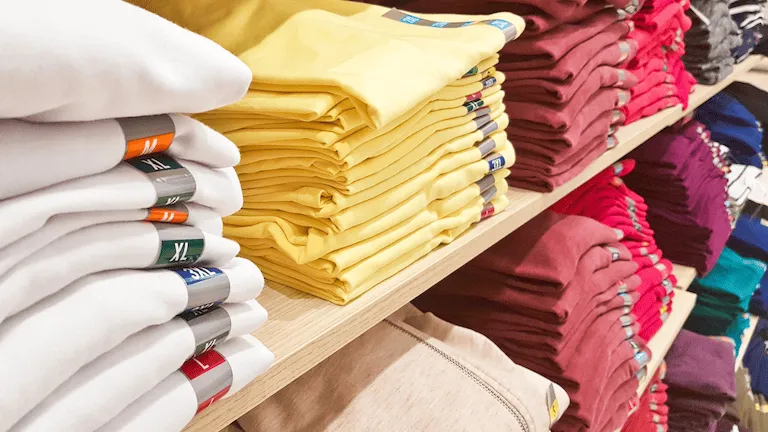 Folded shirts on a shelf.