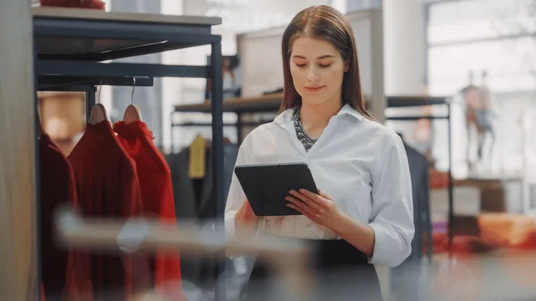 A woman holding a tablet in a department store.