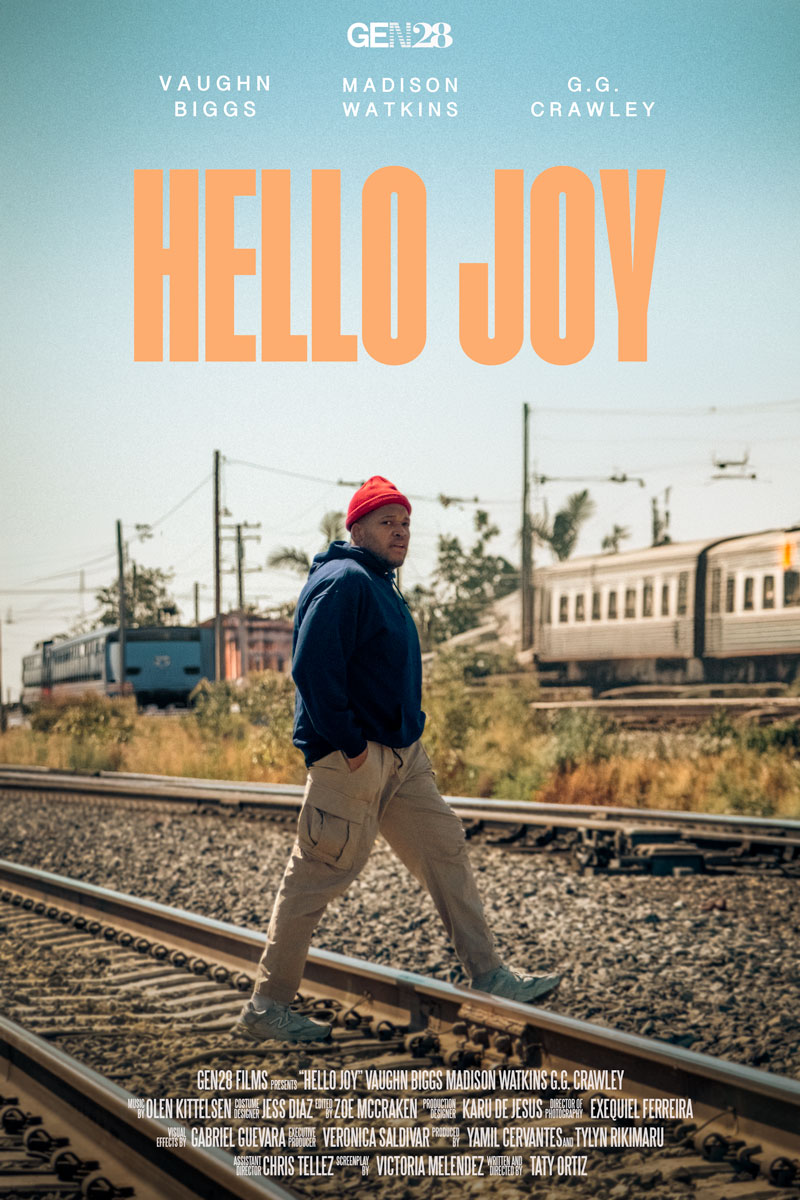 Hello Joy Poster: A young black man walks across train tracks with trains in the background. The Words "Hello Joy" sit at the top of the poster.