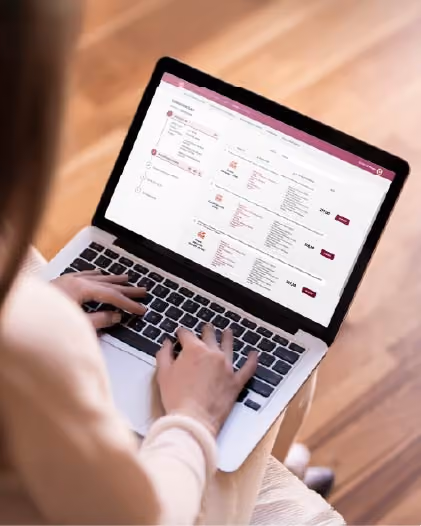 Osoba pisząca na laptopie, który pokazuje stronę internetową z ofertami i cenami.