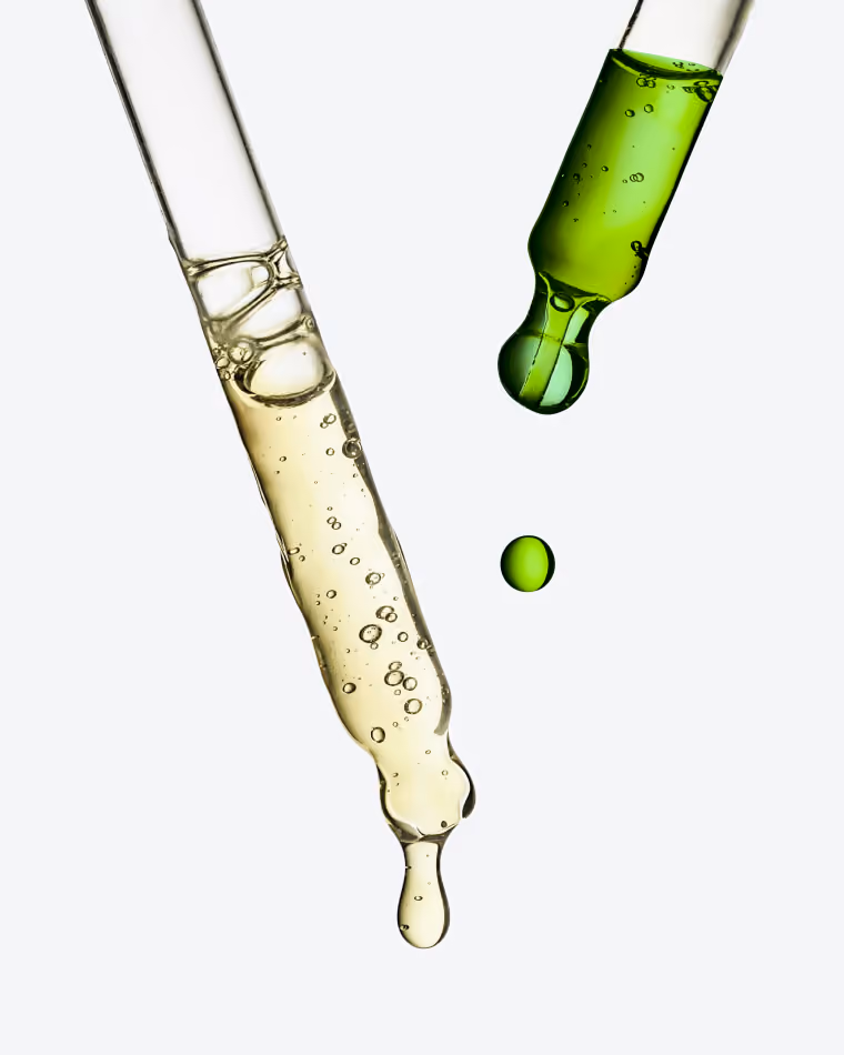 eyedroppers dropping yellow and green liquid
