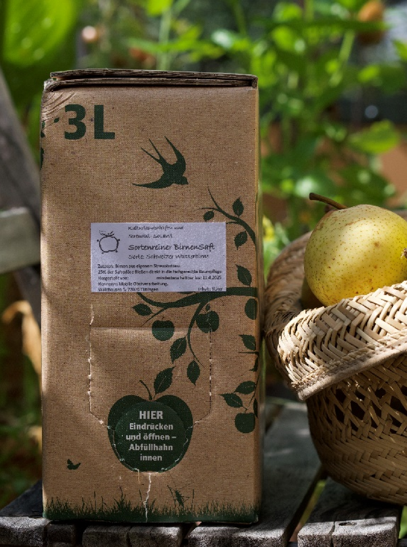3-Liter-Saftbox mit sortenreinem Birnensaft neben einem Korb mit Birnen