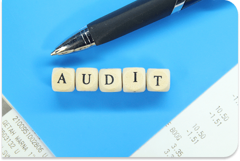 Wooden blocks spelling out "Audit" on a blue back ground