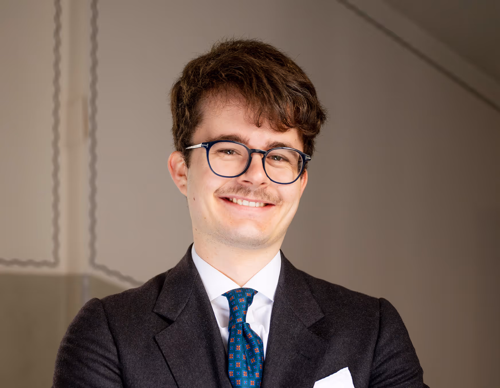 Auf dem Bild zu sehen ist Jakob. Er steht mit dem Armen verschränkt und blickt freundlich in die Kamera.