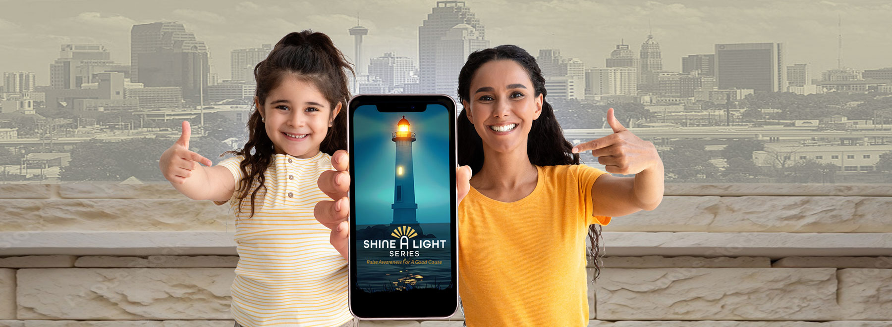 Smiling woman and girl pointing at a smartphone displaying a lighthouse with 'Shine A Light Series' text.