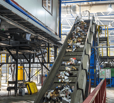 Conveyor belt carrying sorted recyclable materials in a recycling facility