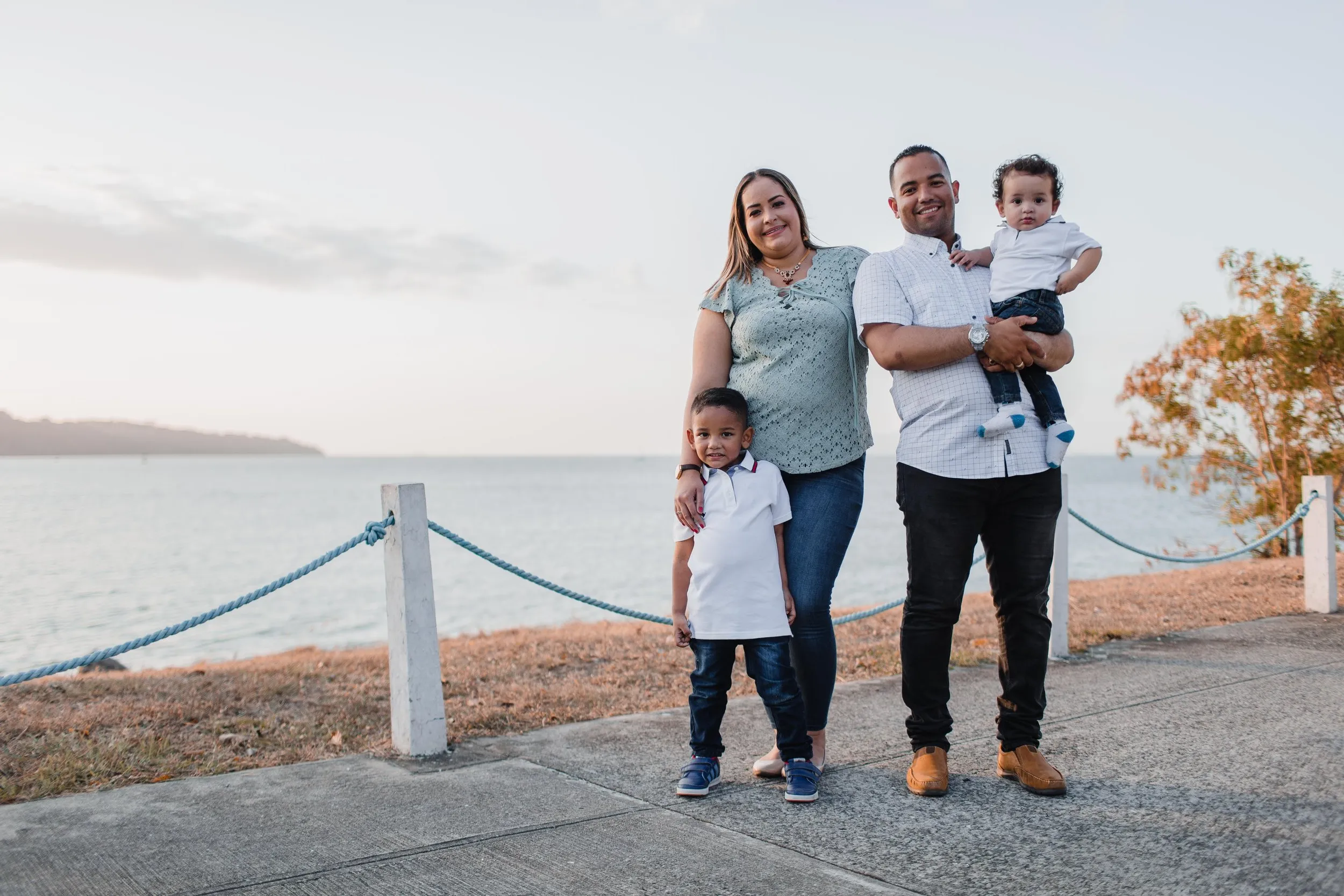 Young family standing on the path in front of a beach